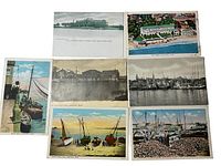 Overview shot of all 7 vintage postcards laid out flat showing various coastal and harbor scenes from Gloucester, MA.