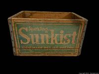 Front view of the crate showing the 'Sparkling Sunkist' green and yellow logo with signs of wear and aged wood.