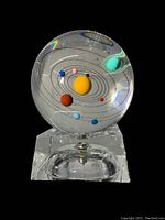 Front view of glass sphere featuring solar system planets and glass stand