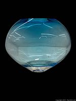 Front angle view of heavy vintage blue glass oblong vase showing the shape and gradient color of blue glass.