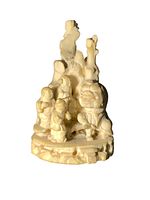 Front view of the small carved Chinese sculpture showing multiple figures and naturalistic base.