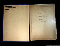 Open view of the homemade stamp collection album showing the inside front cover with handwritten notes and title page.