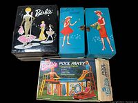 Four vintage Barbie collector boxes including a black Barbie box, two Barbie carrying cases (blue with Barbie & Skipper, blue with Barbie figure), and a Barbie Pool Party set box.