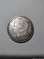 Obverse side of 1921 Morgan Silver Dollar showing Lady Liberty with date and inscription.