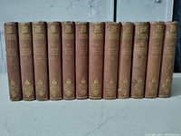 Collection of 12 brown cloth hardcover Shakespeare books, lined up showing spines