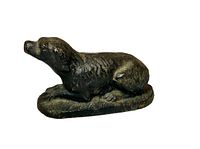 Front left side view of the antique dog doorstop showing dog lying position and textured fur.