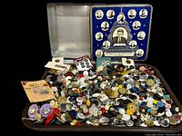 Tin of vintage and antique buttons with JFK-themed lid, buttons spilling from the tin onto a tray