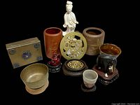 Lot of Asian small porcelain and decorative items arranged on a dark surface showing figurines, vases, and stands