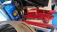 Blue Power Fist 20 ton pneumatic bottle jack and red 2 ton hydraulic floor jack pictured together showing general condition and accessories.