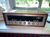 Front view showing wood casing, aluminum faceplate with control knobs and tuning display window