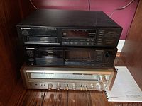 Three stacked Pioneer components in wooden shelf