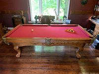 Front-left angle showing full table, carved legs and red felt