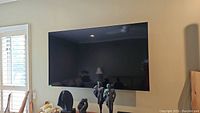 Front view of wall-mounted LG NanoCell TV with decorative items on console below