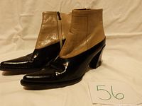 Front and side view of narrow two-tone half boots showing tan and black leather with zipper on inner side.