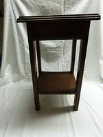 Front view of small wood side table against white backdrop showing clean lines and lower shelf.