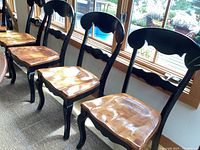 Five of six chairs in a row showing carved backs and contoured seats
