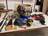 Full view of bucket caddy on blue bucket with all tools and accessories arranged on white table