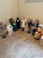 Group of multiple Byers Choice Caroler figurines arranged on carpet
