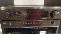 Front view of Denon AVR-2802 receiver with power, volume and input controls, and display panel.