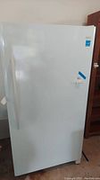 Full exterior front view of white upright freezer