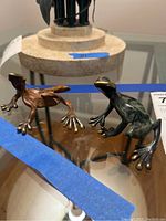 Two frog figurines displayed on glass table