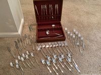 Full set arranged on carpet with wooden storage box open, utensils laid out
