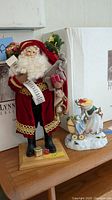Photo of Lynn Haney Santa figurine with original box, standing with Lenox snowman figure