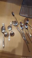 Top view of all spoons laid out on table showing varied lengths and condition.