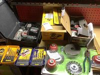Photo shows Porter Cable drill with battery and charger in a soft case on the left; Dewalt sander box in center; Chicago Electric angle grinder box on right; multiple sets of drill bits and grinding attachments spread on surface