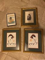 Four framed prints on floor; three 15x12 inch prints, one smaller 9.5x6.5 inch print; prints mostly show Aboriginal designs and figures
