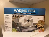 Box front showing Waring Pro Food Slicer with 7.5-inch diameter stainless steel blade and product details.