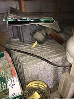 Photo showing stacked granite pavers under steps, with two plunger drain tools and safety helmets on top.