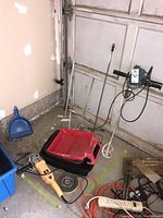 Photo shows yellow and black 7-inch angle grinder on the floor near a blue dustpan and red/black mixing bucket.
