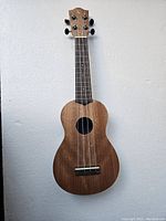 Full view of the Tanglewood TU1 ukulele showing body, neck, and headstock with visible wood grain and four strings.