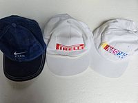 Three vintage hats side by side; blue Nike Italia, white Pirelli, white NASCAR