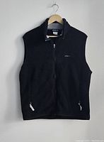 Full view of black Patagonia Synchilla fleece vest with zipper front and two pockets.
