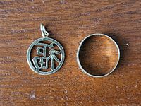 Pendant and ring placed side by side on wooden surface showing the two pieces included in the lot.