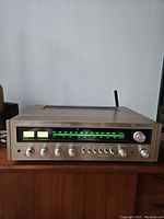 Front view powered on showing illuminated green tuning scale and dual meters