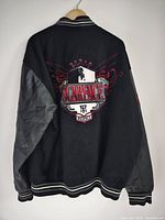 Back view showing black wool and leather jacket with large embroidered Scarface crest featuring a crowned shield, wings, and 'Respect' text beneath.