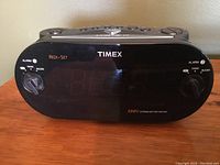 Front view of Timex digital clock radio with dual alarm knobs and display screen.