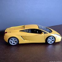 Side view of the yellow Lamborghini Gallardo diecast model highlighting body shape and chrome rims.