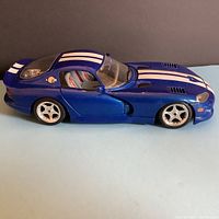 Side view of blue Bourago Dodge Viper GTS Coupe diecast model with white racing stripes, driver side door closed, showing profile and wheels