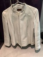 Front view of ivory Danier leather jacket on a hanger.