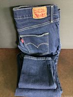 Folded Levi's dark blue denim ladies slimming skinny jeans showing back pocket, leather patch, and red tab.