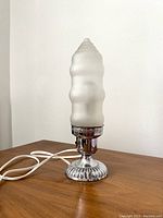 Front view of the lamp showing full height, frosted textured glass shade, silver-tone base, and power cord