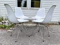 Four chairs arranged outdoors in a circle showing full set and overall style