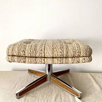 Side view of stool showing beige textured fabric cushion and chrome base with teak wood inlays on legs.