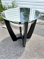 Full view of vintage round side table showing the removable mirror top reflecting surroundings with a black wooden base and silver metal ring.