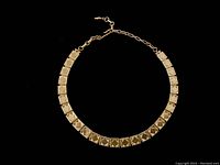 Full view of the vintage gold tone Vendome necklace laid flat showing square pyramid segments and extension chain clasp.