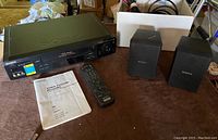 Sony Hi-Fi Stereo VCR with two Sony speakers, remote, and instruction manual arranged on a table.